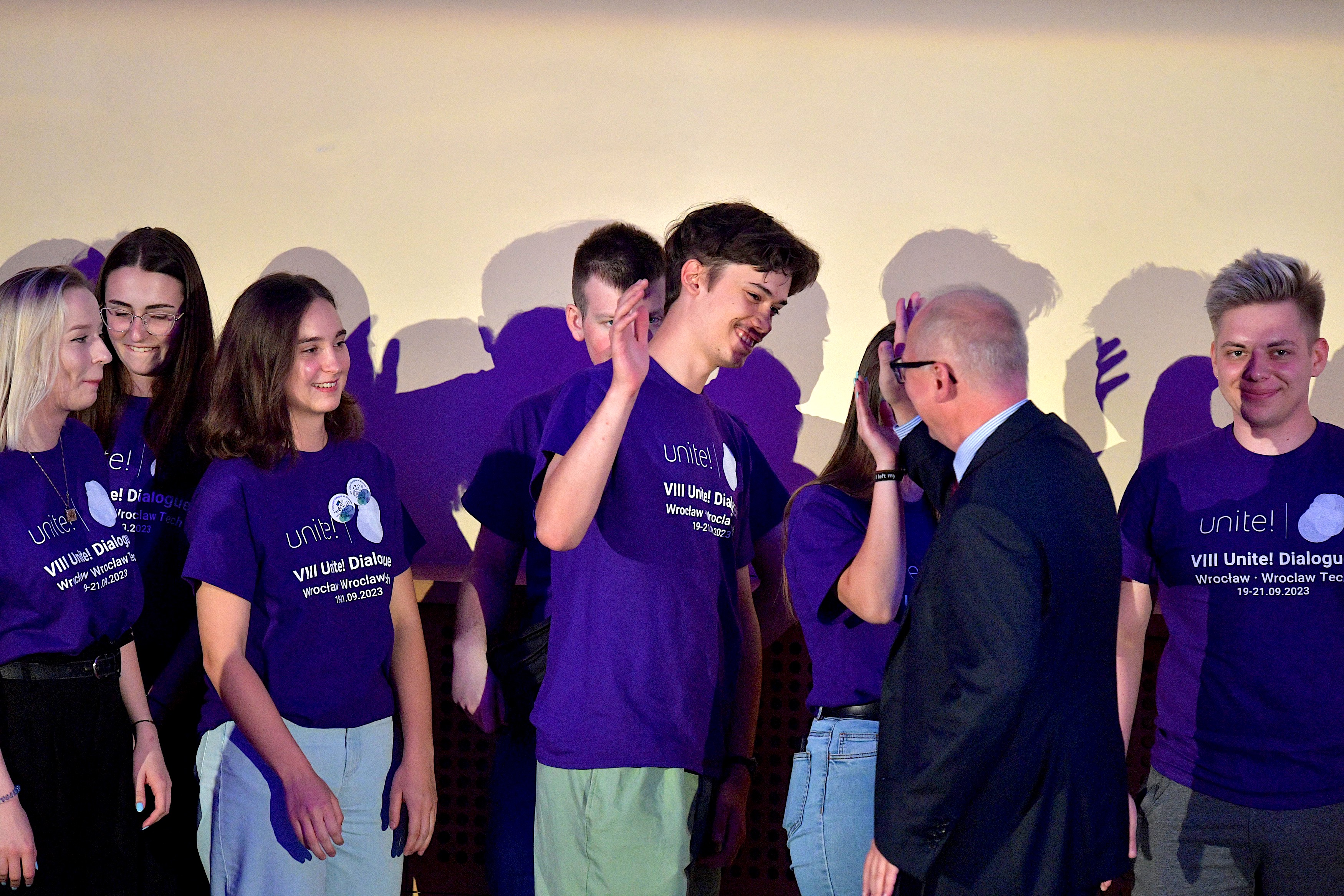 Wroclaw Tech's rector giving a high five to the students who were part of the organisation team