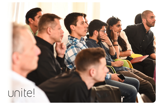 A group of people sitting as public in a conference and looking very interested