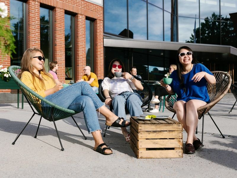 Three students outdoors sunbathing 