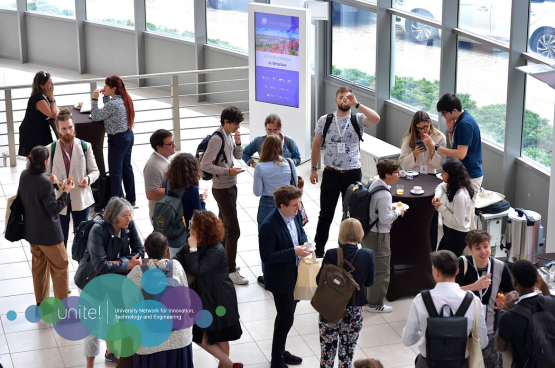 A group of people made up of students, teachers, staff and researchers discussing in various groups during the coffee break