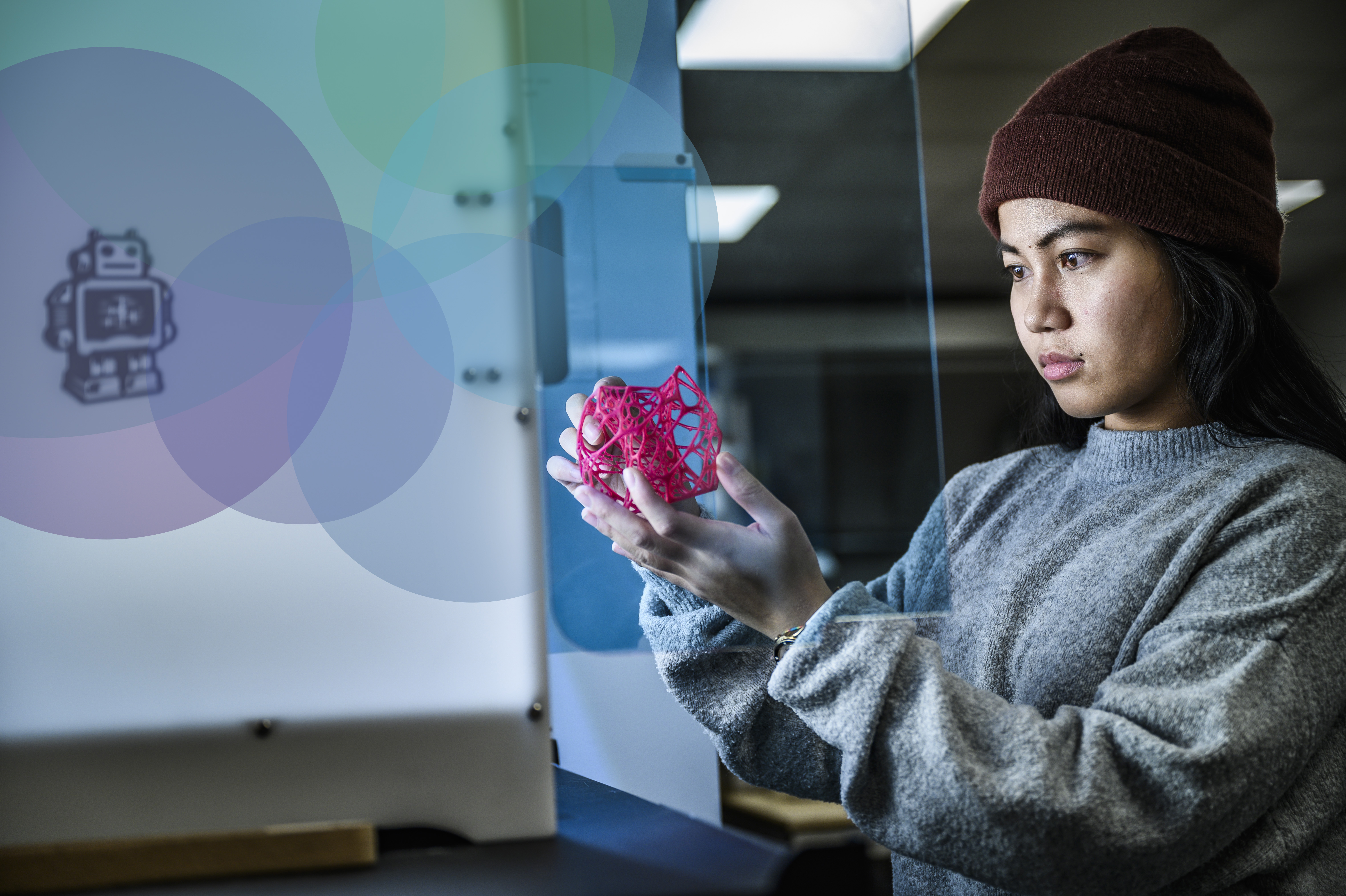 A student holding a geometrical shape made out of a 3d printer.